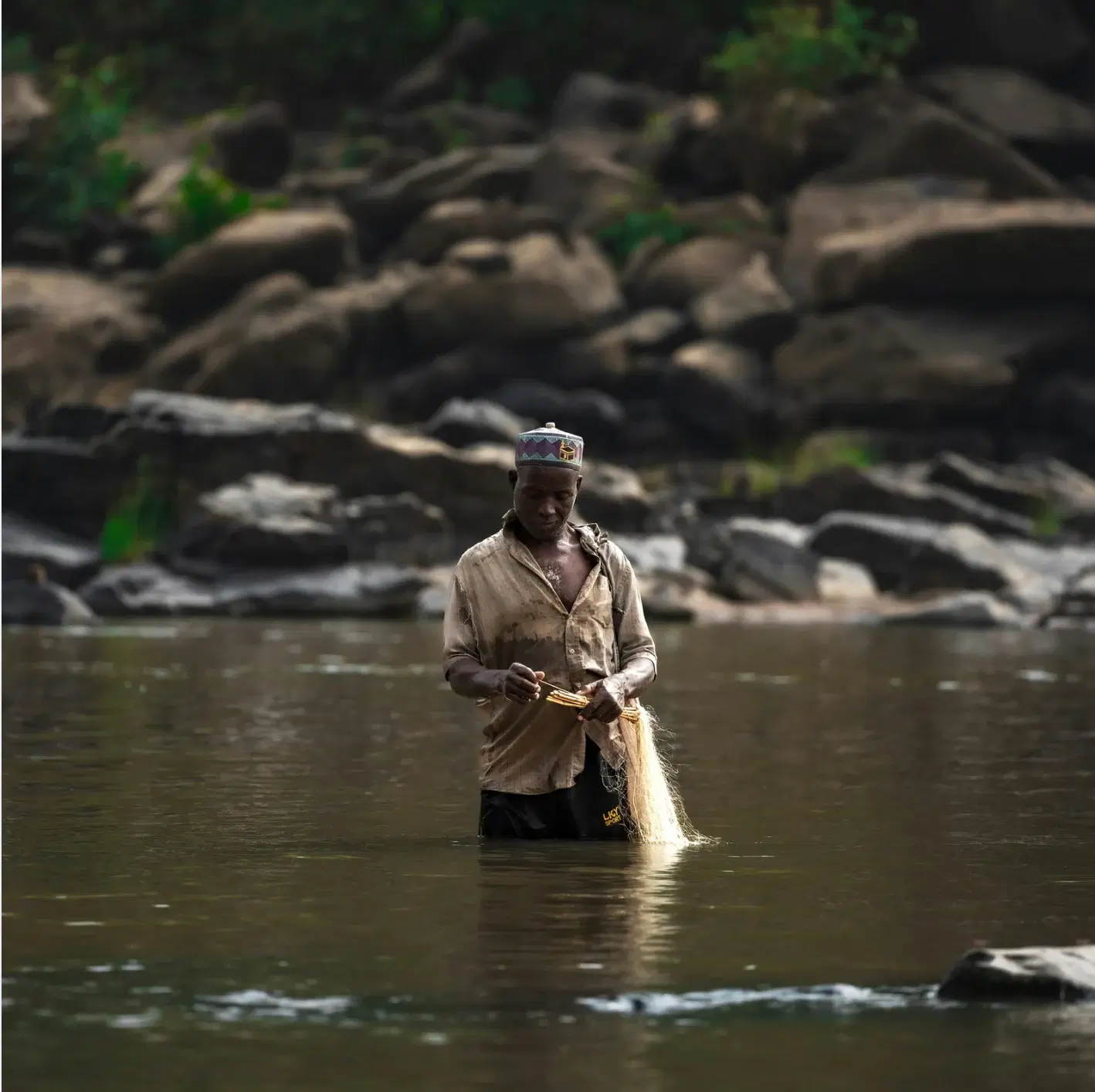 A middle aged man fishing in a lake